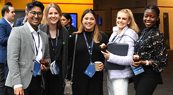 A group of people wearing lanyards gather together for a photograph.