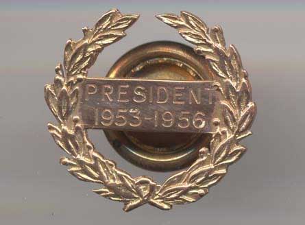 Ornate golden badge with a wreath design, with the words: "President 1953-1956"