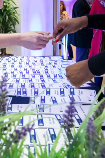 A person hands a pen to someone else, with only their hands in shot.