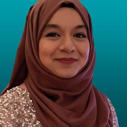 Headshot of Tahmina from the shoulders up with her head with a brown hijab.