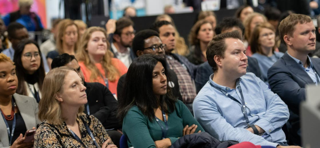 A group of seated GPs attending an event listen attentively to the speaker, not in shot.