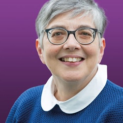 Headshot of Dr Mona Aquilina from the shoulders up smiling