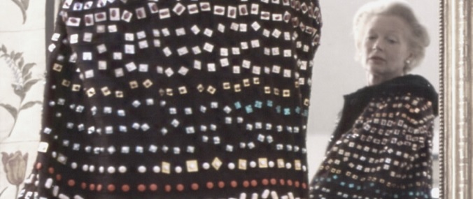 A woman wearing an artistic shawl with rows of square and diamond sequins.