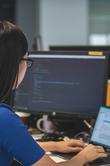 A small card image of a seated woman using a laptop at a desk.