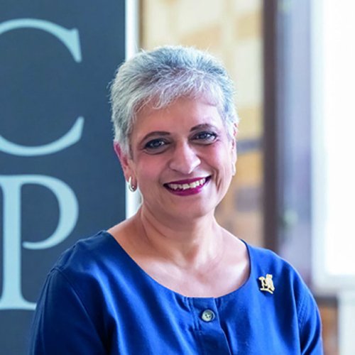 A square photo of RCGP Chair Professor Kamila Hawthorne smiling in front of a large RCGP sign.