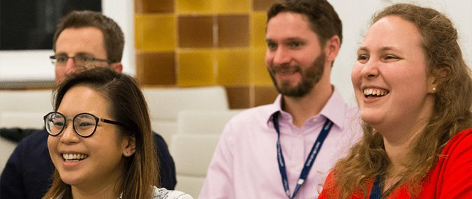 Four seated people looking the same way, engaging with someone who is out of shot. 